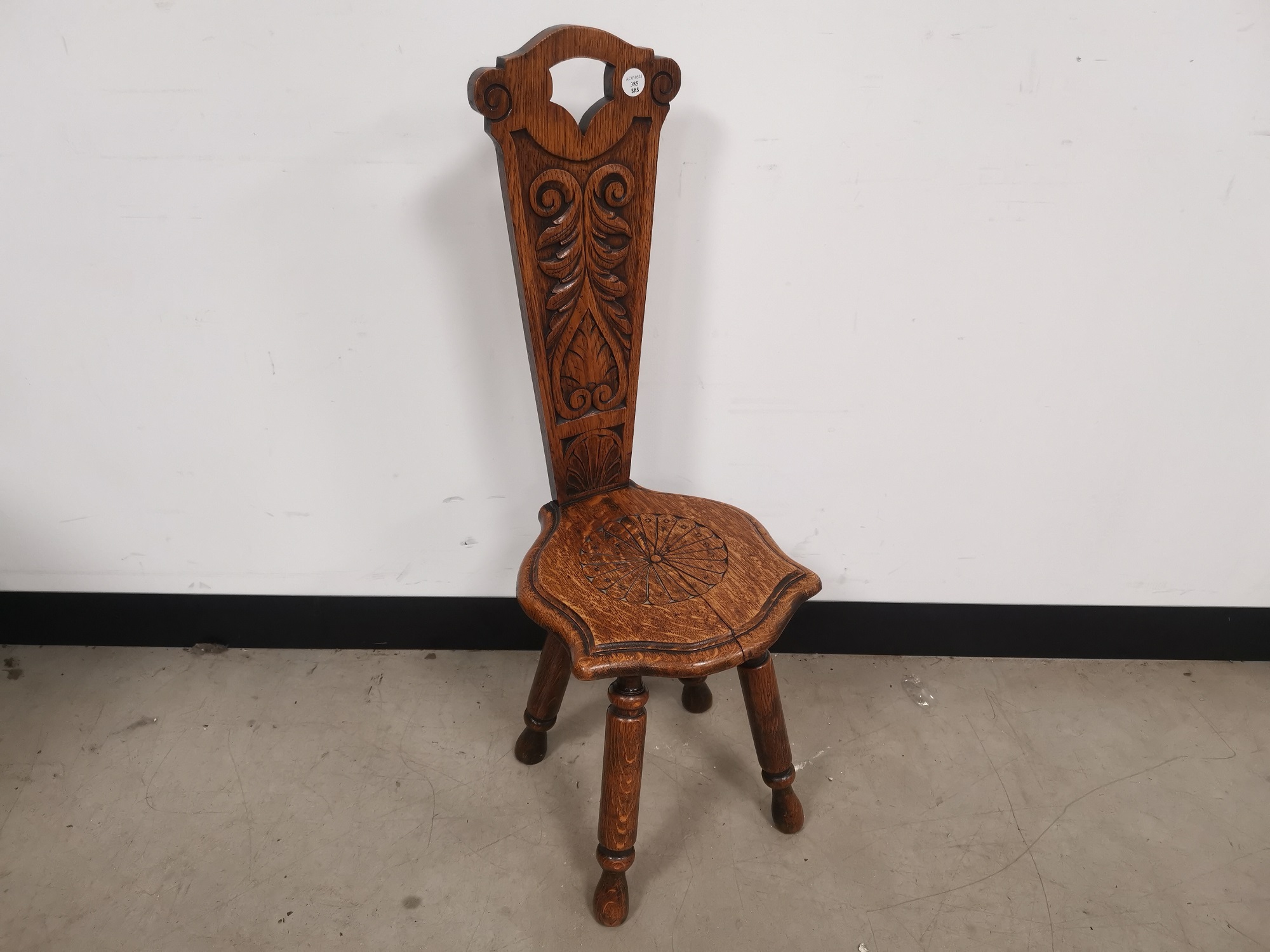 Oak spinning stool, With carved detail to the seat and back rest.