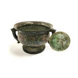 An interesting Chinese cast bronze censer or food vessell of archaic form with twin handled Taotie