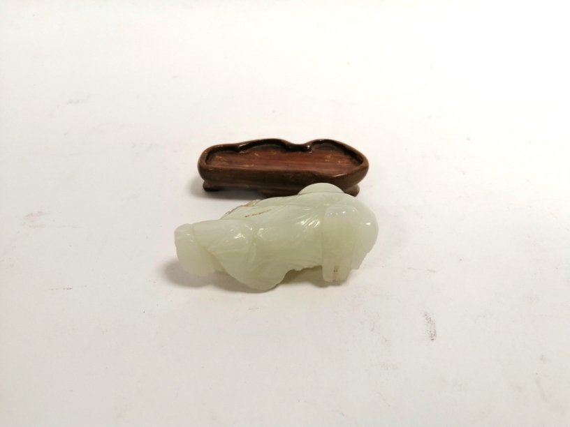 A Chinese carved jade figure clasping a rodent and a vase, with a wooden stand, 6.5cm x 3.5cm x 2. - Image 4 of 4