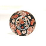 An Imari deep dish with central floral display and surrounding foliated cartouches, with mythical