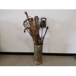 Embossed brass stick stand, Together with an assortment of sticks, Lacrosse sticks.