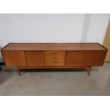 Mid 20th Century teak sideboard, with three central drawers, and sliding doors to either side. 233cm