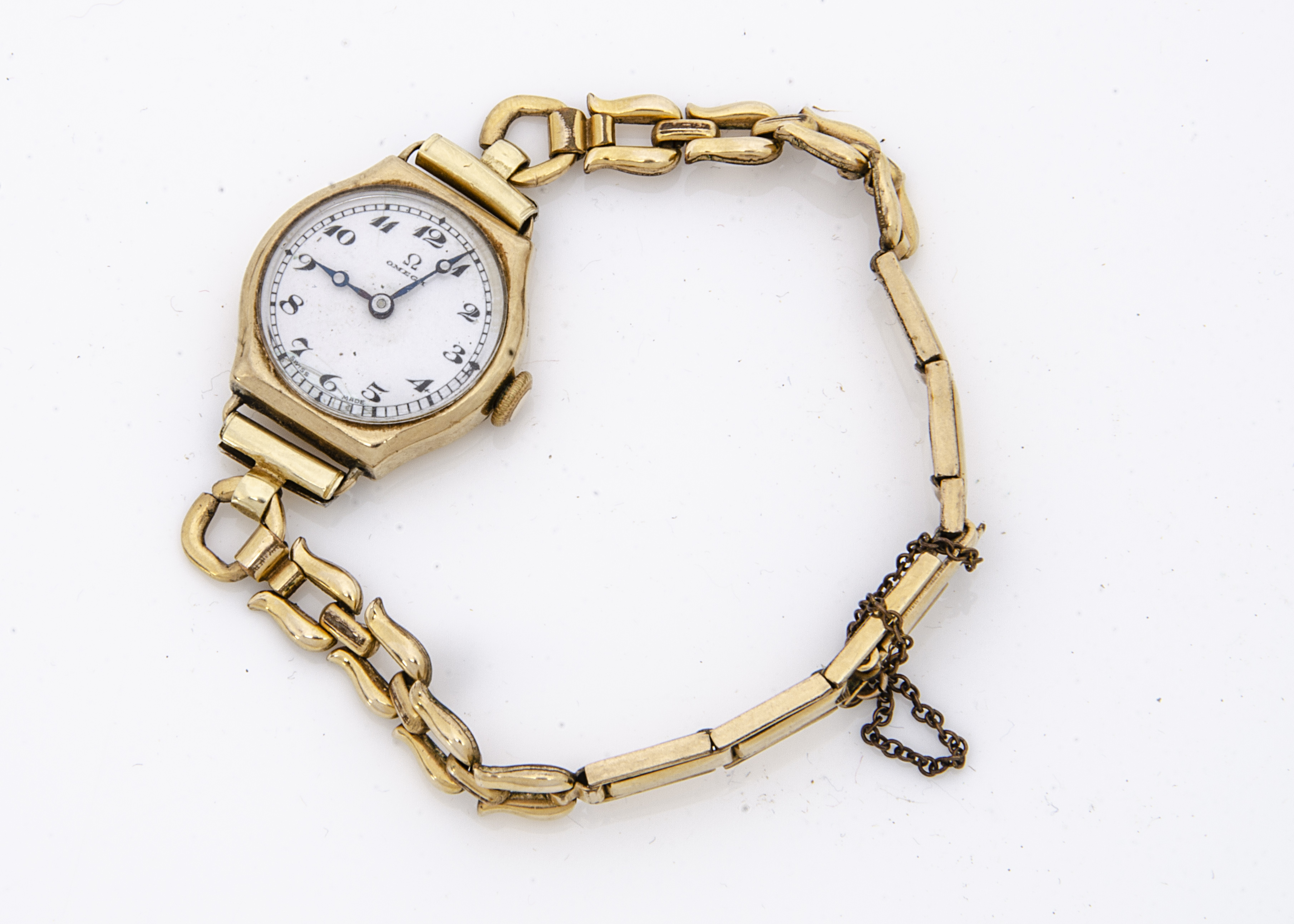 A 1930s Omega 9ct gold cased lady's wristwatch, 20mm, cracked white enamel dial, on a rolled gold