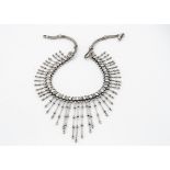 A Middle Eastern white metal fringe necklace, with graduated baton drops, on a herringbone chain,