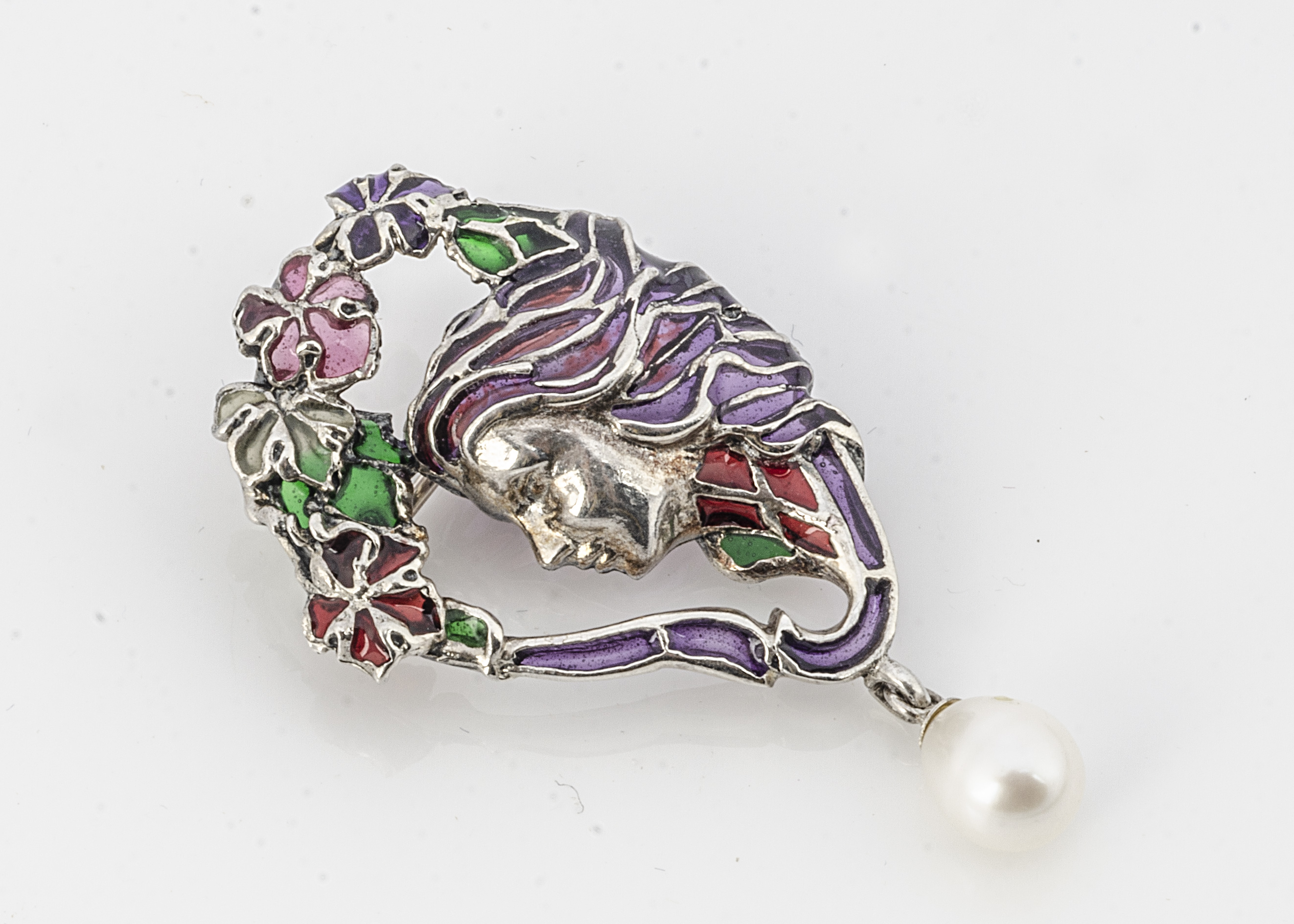 A white metal plique a jour Art Nouveau femme fatale style brooch, with pear shaped cultured