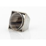 A 1970s white metal dress ring, of square form with circular banded agate centre, ring size K, 20g
