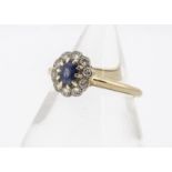 A sapphire and diamond cluster ring, the oval mixed cut sapphire heavily abraded, in claw setting