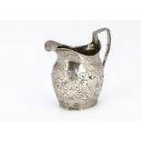 A George III silver milk jug, helmet shaped with later embossed design and repair to handle, marks