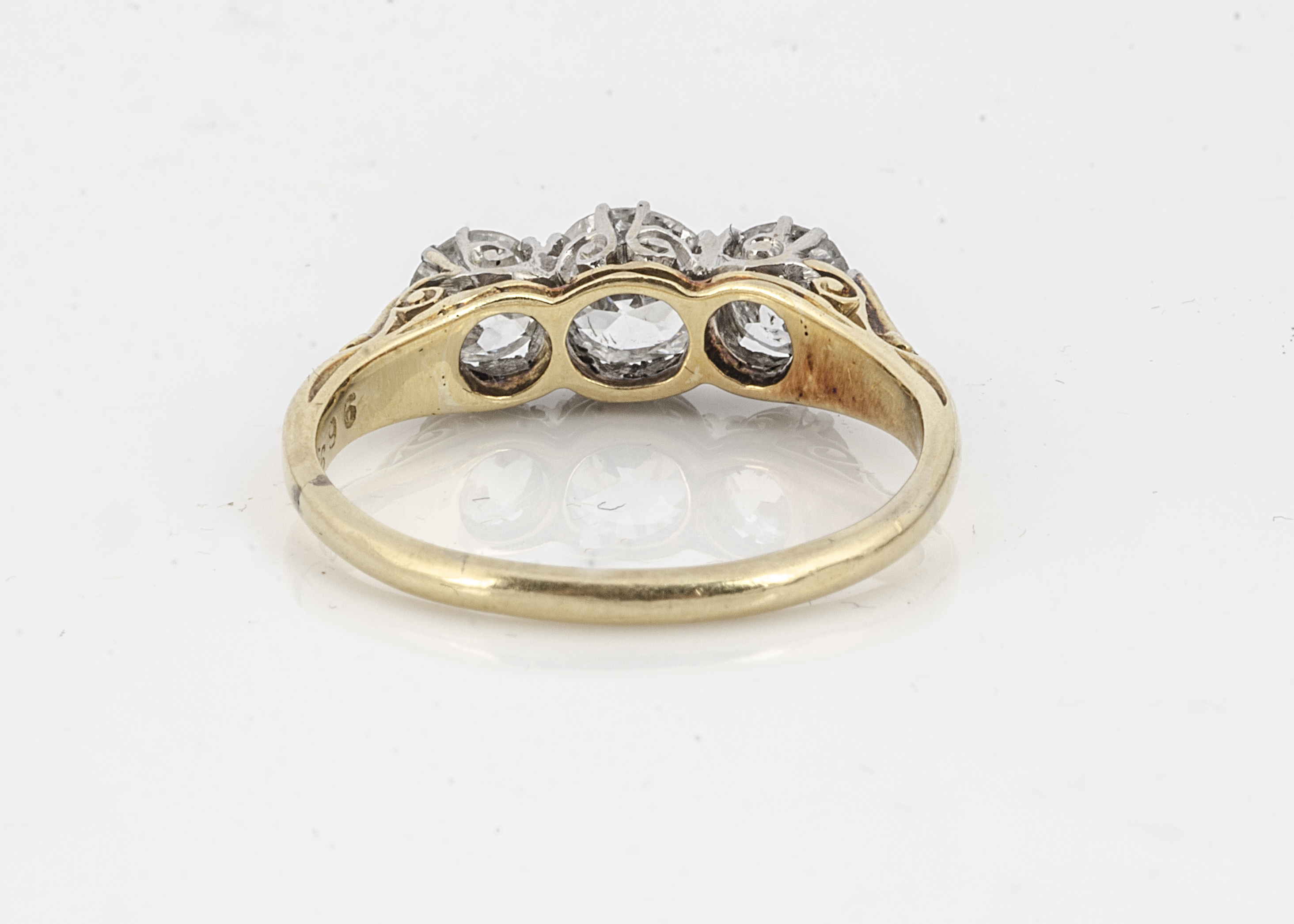 A three stone diamond ring, the old cuts in claw setting on a yellow metal shank marked PLAT and - Image 2 of 2