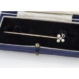 An Edwardian pearl and diamond stick pin, with flower terminal on unmarked yellow metal pin, 5.