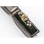 A boxed Edwardian 15ct gold bangle, the hinged bangle of pierced design with gold, pearl and ruby