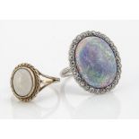 A large black opal and diamond bezel set dress ring, in white metal, the oval black opal with old