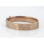 A 9ct gold hinged bangle, with engraved floral decoration, 6cm x 5.2cm internal measurement, 17.2g