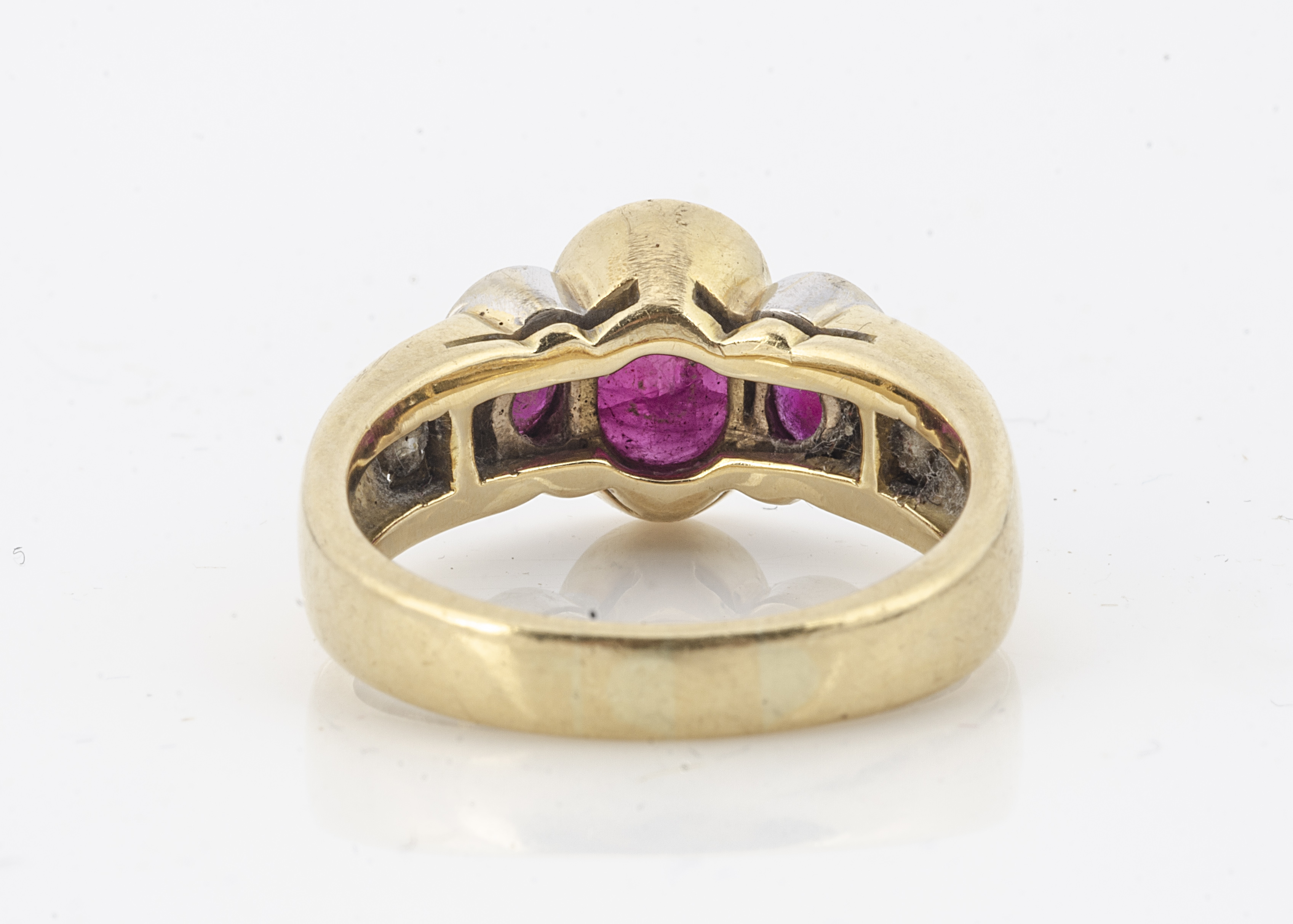 An 18ct gold three stone ruby and diamond set dress ring, the three oval cut rubies in rubbed over - Image 2 of 2