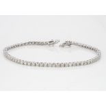 An 18ct white gold diamond line bracelet, the seventy brilliant cuts in claw settings, 19cm long,