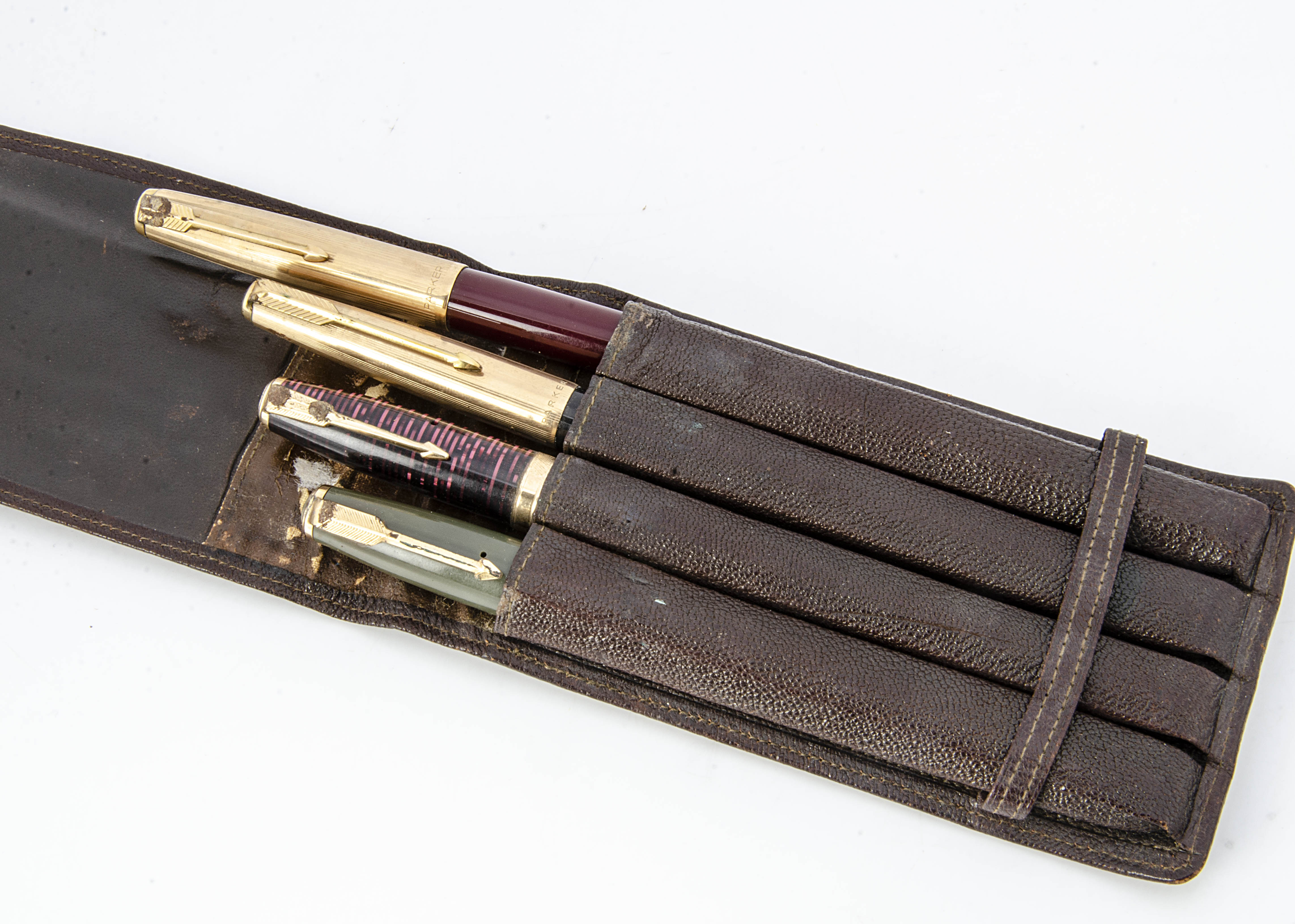 Four vintage fountain pens, including a Parker Duofold, a Parker Vacumatic, a Parker 61, and