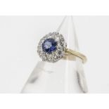 A yellow gold and sapphire and diamond set cluster ring, the circular mixed cut central sapphire