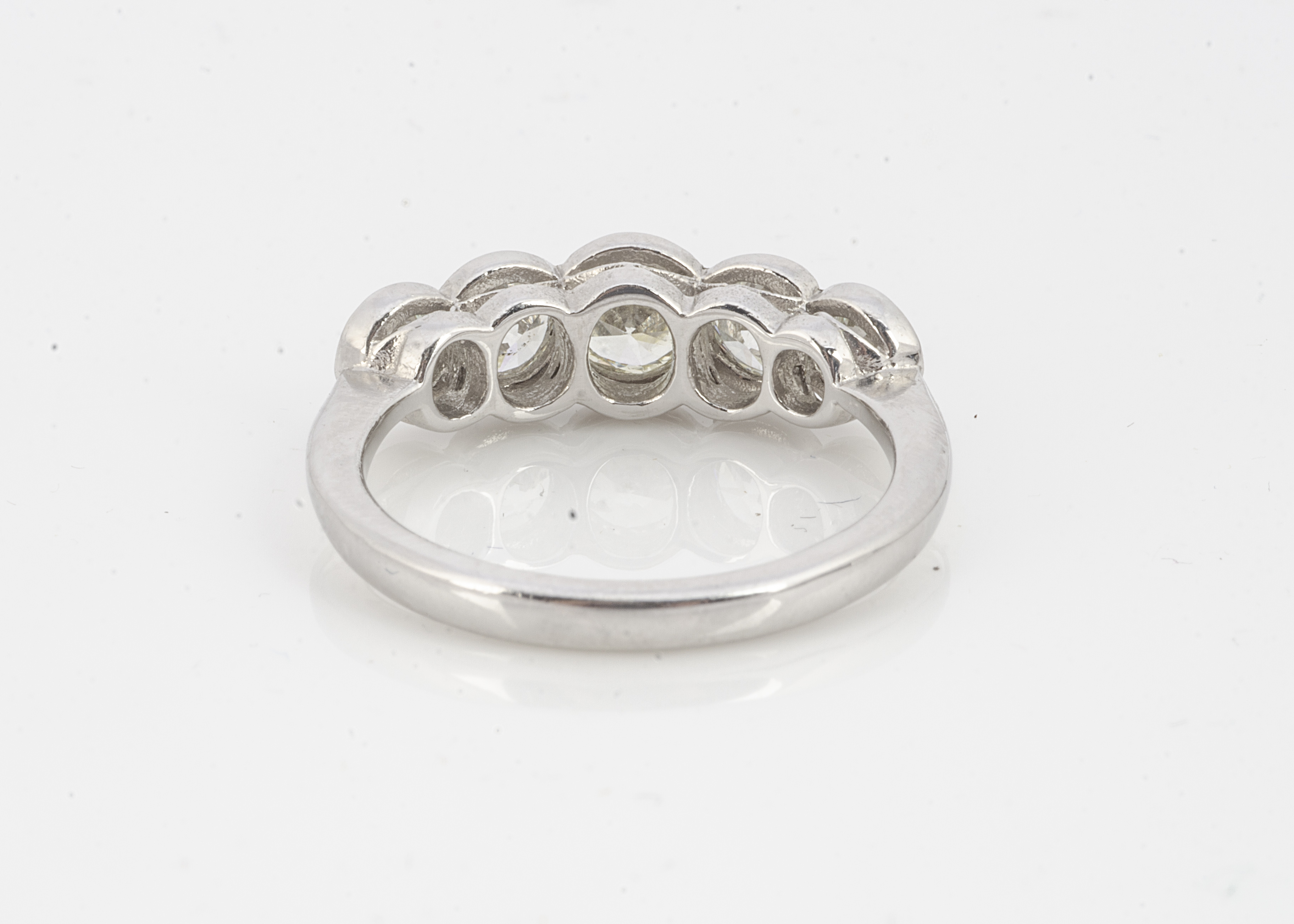 A diamond five stone platinum set dress ring, brilliant cuts in rubbed over settings on white - Image 2 of 2