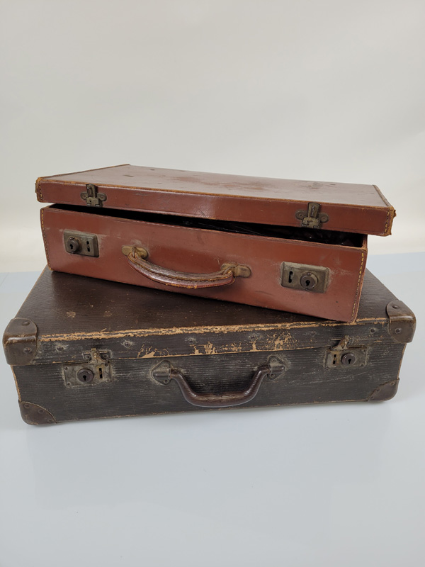Two vintage leather suitcases, one with base metal corners, plastic handle, the other with leather