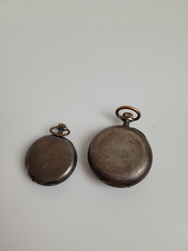 Two lady's gun metal open faced fob watches, the larger with white face, black roman numerals, - Image 2 of 2