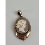 A 19th Century shell cameo and base metal oval drop pendant, with locket box back, the oval front