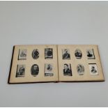 An Ogden's cigarette card album, filled with Boer War series