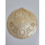 A mother of pearl pilgrim shell, with carved and pierced decoration depicting the Nativity with