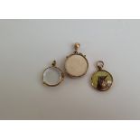 Three early 20th Century open faced circular lockets, one marked 9ct gold, the other in yellow metal