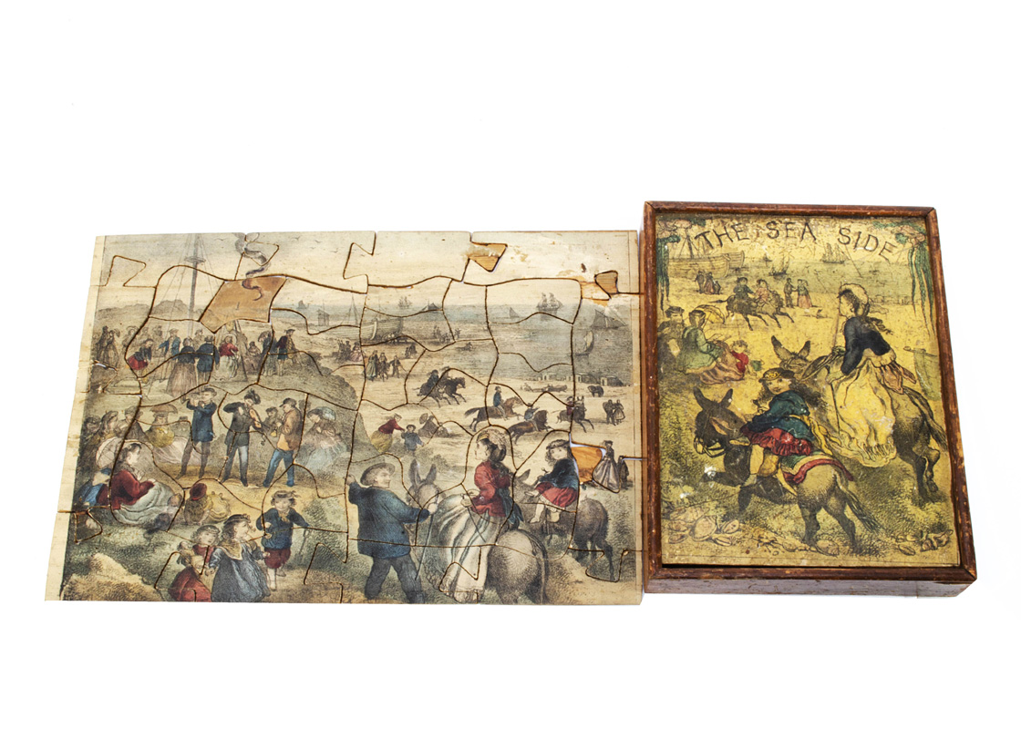 A 19th century dissected puzzle The Sea Side, hand coloured paper laid on wood, in original wooden