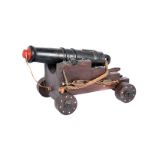 A wooden model of a ships cannon, possibly a 12 pounder long gun, having applied rope and chain,