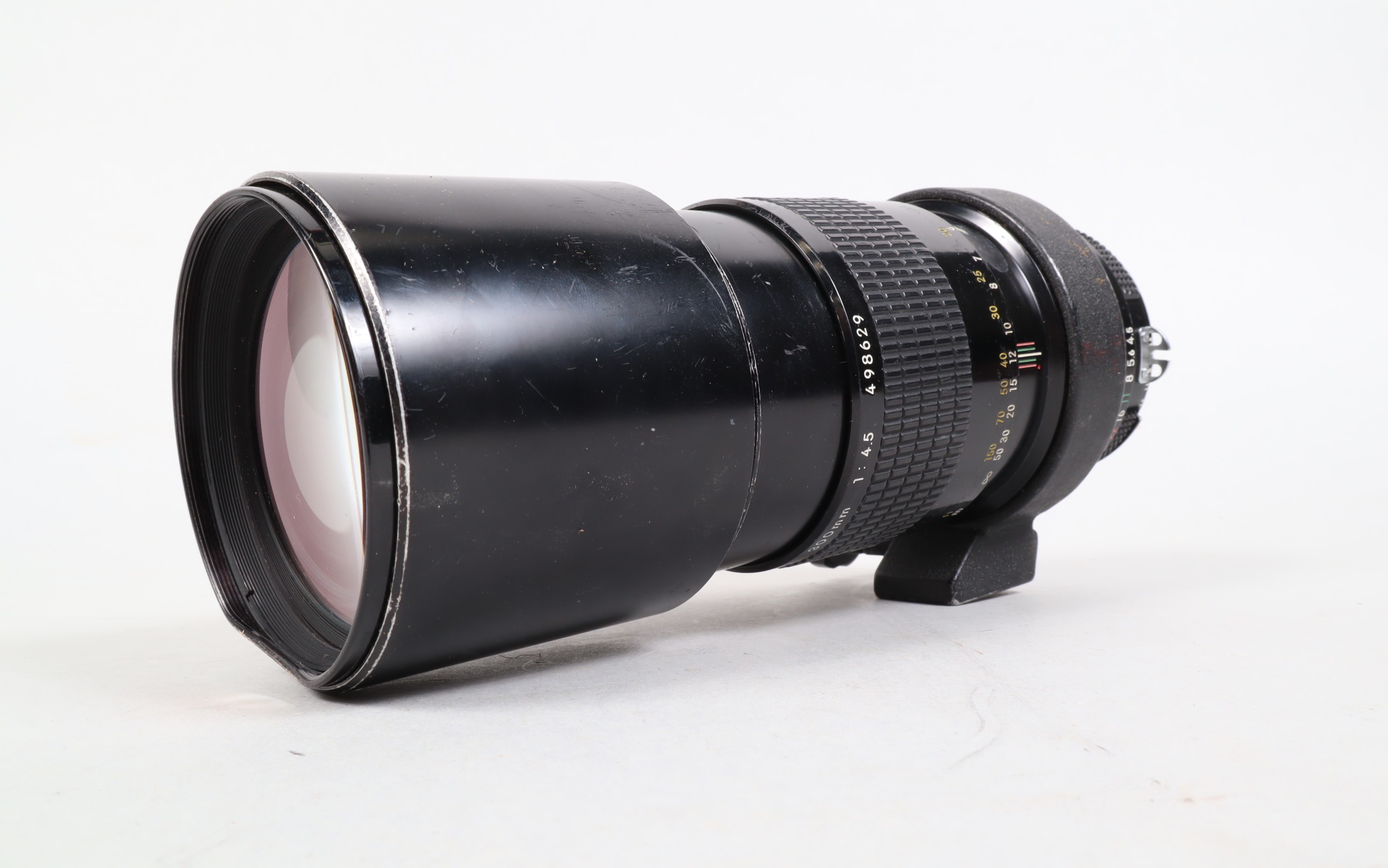 A Nikon Nikkor 300mm f/4.5 Ai Lens, serial no 498629, barrel G, some paint wear, some brassing to