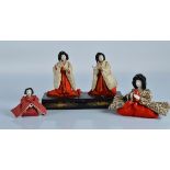 Four Japanese gofun girls festival dolls, on lacquered stands, 7 inch (18cm) overall height and