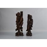 Two Chinese hardwood lamp bases, carved wood in the form of men. 54cm and 49cm tall.