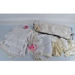 A quantity of dolls clothing, all on hangers, including various 19th Century silk christening
