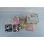 A quantity of doll outfits, including a burgundy silk dress with matching hat, a pink outfit with