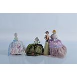 Three porcelain half doll pin cushions, in lilac, green and white, one with leg adornment, a 1920s