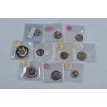 Ten Georgian and Victorian enamel coins, including some with brooch mountings and suspension loops