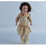 A Heubach child doll, with weighted brown eyes, synthetic brown wig in a silk and orange dress,