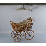 A contemporary wicker and ratan Edwardian style doll pram, with sprung S shape supports on metal