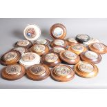 A collection of 22 Staffordshire pot lids, all in wooden frames, with titles such as The Game Bag,
