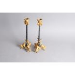 A pair of Regency period bronze and ormolu candlesticks, 31.5cm, having triform bases with roaring