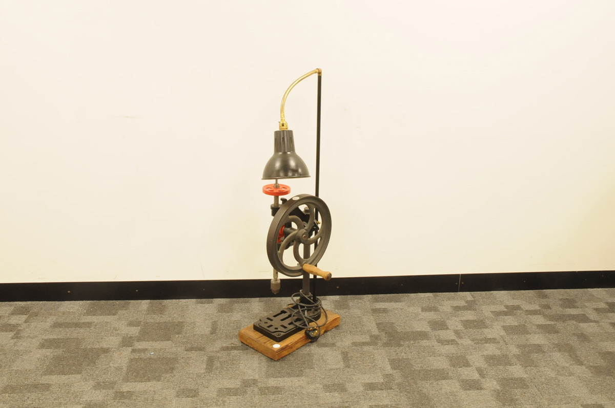 A vintage cast iron pillar drill now converted to a lamp, 105cm, on wooden base and appears to still