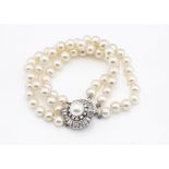 A diamond and pearl bracelet, the three strand uniform bracelet with cluster diamond clasp, 19cm,