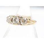 A 14ct gold three stone diamond dress ring, the three old cuts in yellow gold carved mount,