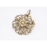 A 15ct gold Edwardian pearl brooch or pendant, of circular shape with pierced floral design, with