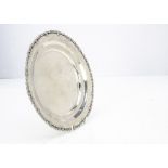 A vintage Egyptian white metal circular tray, with shaped rim, 11.5ozt and 25cm diameter