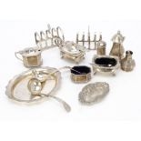 A group of 20th Century silver items, including two toast racks, two sauce ladles, a small oval tray