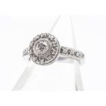 A round diamond cluster ring, in white 14ct gold, the brilliant cut in milled setting surrounded