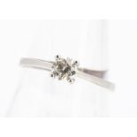 A diamond solitaire in white hallmarked gold, brilliant cut in four claw setting, ring size R 1/2,