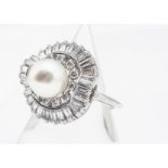 A pearl and diamond cluster ring, the central spherical pearl with creamy overtones in a retro
